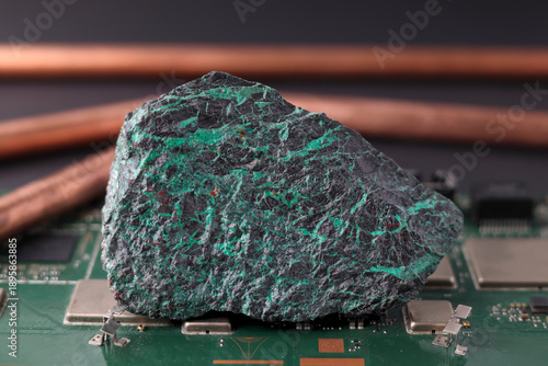 Fotografia Copper ore and electronic circuit board, plumbing pipe in background