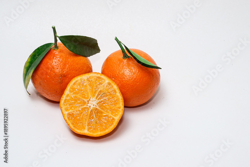 Fresh orange fruit with slices on isolated white background.