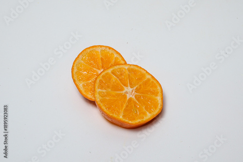 Fresh orange fruit with slices on isolated white background.