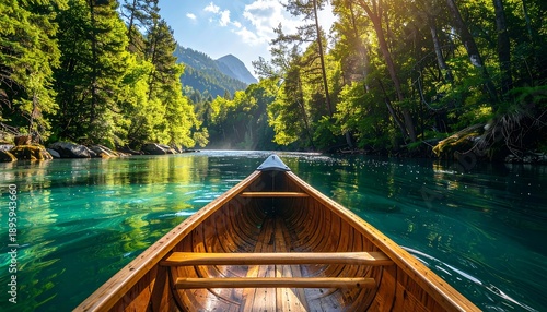 A wooden canoe glides down a clear river surrounded by lush green trees, towards mountains under a bright sunny sky