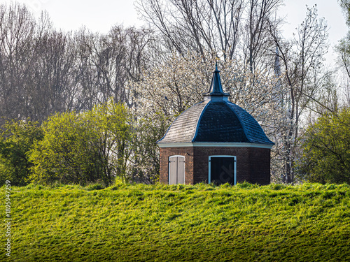 Фотография Small brick capstan house on a grassy dike