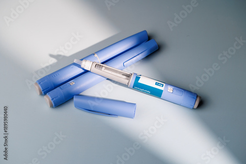 Close up of semaglutide GLP-1 pens for weight loss and diabetes treatment on a blue gradient background for healthcare and medicine.