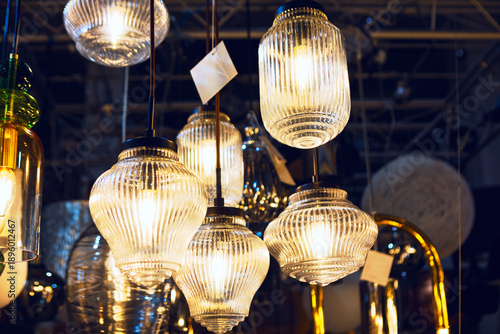 Fotografie Ribbed glass pendant lights glows warmly in showroom, each fixture showcasing subtle variations in shape and size