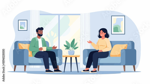 Two people sit in comfortable chairs in a room, conversing