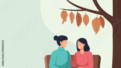 Two people sit under a tree with autumn leaves