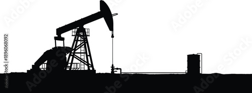 Oil pumpjack operating in a field at sunset