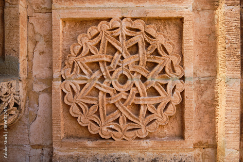 Detailed stone relief featuring an intricate geometric and floral interlace pattern carved into a square architectural panel. Deyrulzafaran monastery, Mardin, Turkey