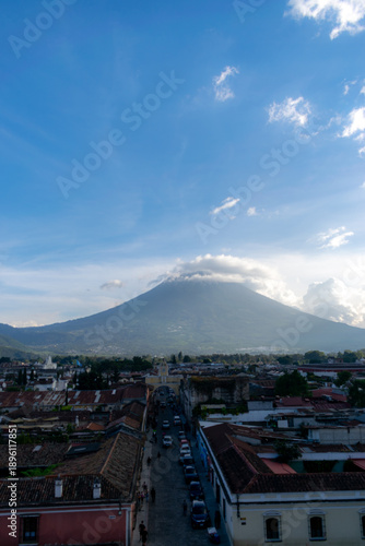Scenic overlook of Antigua Guatemala featuring colorful historic architecture framed by the towering Agua volcano