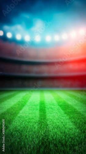 Blurred stadium interior with bright floodlights illuminating  striped green field background