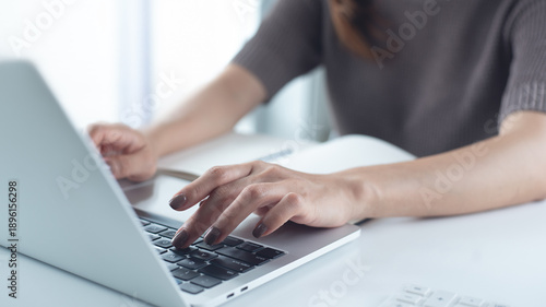 Close up, woman hand typing on laptop computer keyboard. Business woman online working on laptop computer, surfing the internet, searching the information at home office, e-learning
