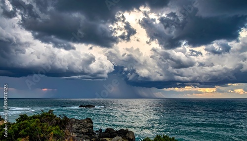Dramatic seascape with a stormy sky and sun beams breaking through heavy clouds over the ocean