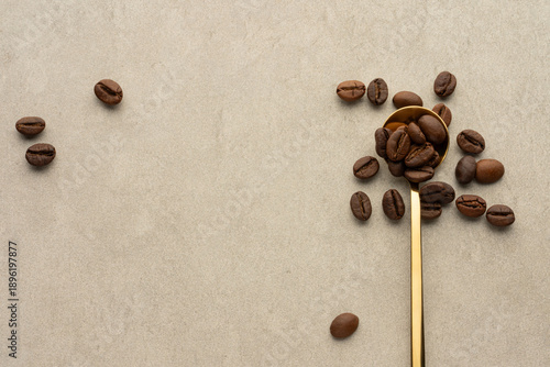 gray stone background with a spoon and coffee beans