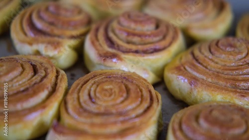 close up view of fresh baked cinnamon rolls out of oven on tray