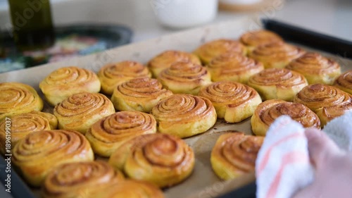 close up view of fresh baked cinnamon rolls out of oven on tray