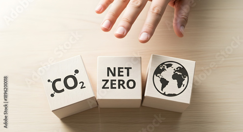 Hand reaching for wooden blocks with CO2, Net Zero, and Earth symbols, depicting global commitment to carbon neutrality, climate action, and sustainable environmental future