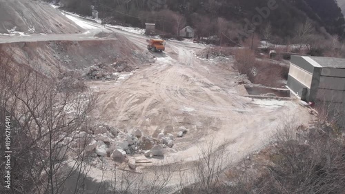 A quarry dump truck delivers and unloads rock