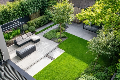 Green garden design features grass and stone pathways, seating area, and plants in a private outdoor space during daytime