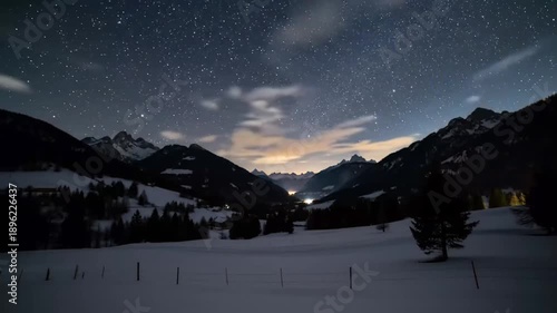 Night sky over mountain range revealing stars and winter landscape