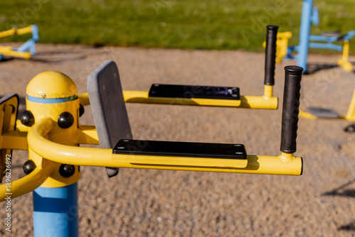 Cuadro en lienzo Close-up of yellow and blue outdoor gym equipment handles in a sunny public park