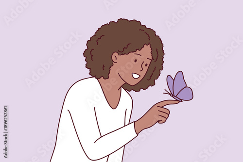 African American girl with autism spectrum disorder holding a butterfly on her finger. Symbol of neurodiversity, peace, and inclusion for Zero Discrimination Day.
