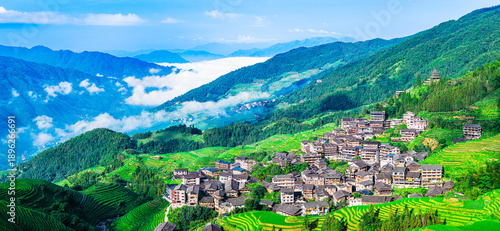 Φωτογραφία A beautiful aerial view of a traditional village with green rice terraces and mountains under a blue sky in Guilin, China