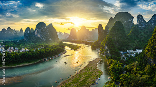 Tableau sur toile An aerial view of a beautiful river winding through green karst mountains at sunset in Guilin, China
