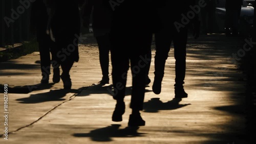 silhouettes of people walking on the city. Legs of pedestrians. Unrecognizable people walking in the backlight.