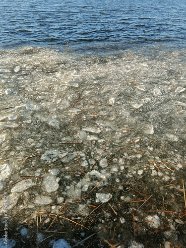 Ice floes in river. Floating ice pieces on river water in winter daylight. Concept of natural winter background with copy space for banner, website header, climate content.