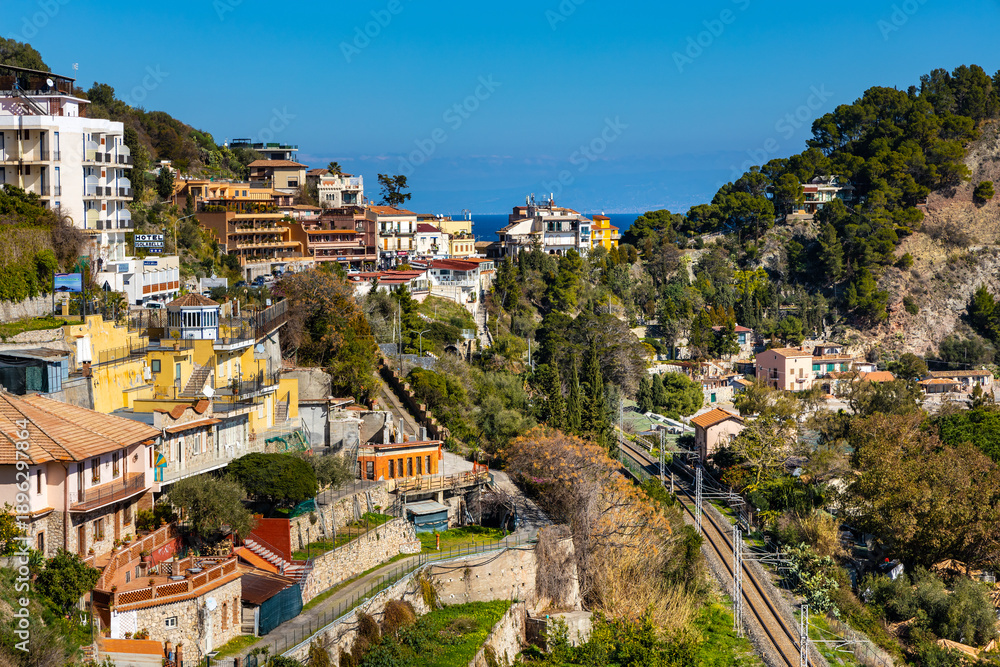 Fototapeta premium Panoramic view of Taormina and Mazzaro town at Ionian sea shore seen from Funivia Cable Car gondola in Messina region of Sicily in Italy