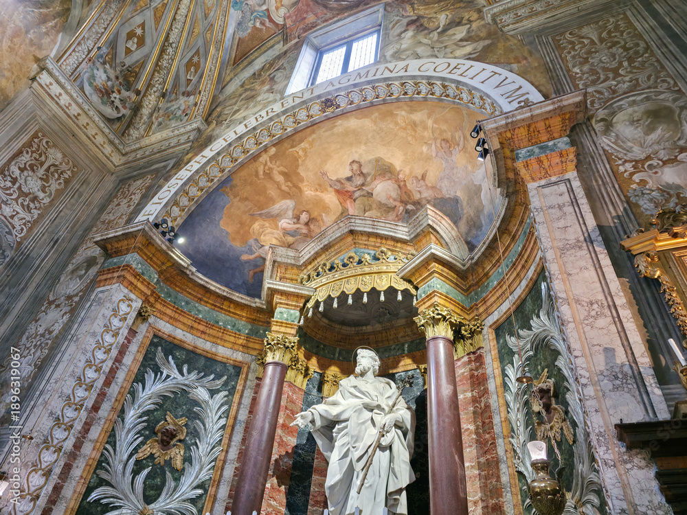Fototapeta premium A richly decorated interior of the Oratory of St. Joseph in Urbino, featuring a central statue, marble walls, golden columns, and detailed frescoes