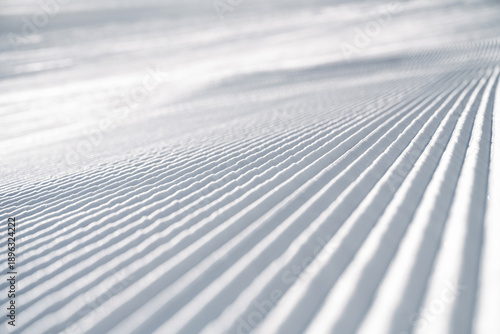 Schilderij op canvas Corduroy snow texture on a freshly groomed ski slope, showing clean parallel ridges and detailed winter snow structure, ideal as background or texture for winter sports themes
