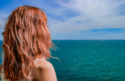 Rothaarige Frau vor einem Blauen Meer