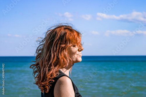 Rothaarige Frau vor einem Blauen Meer