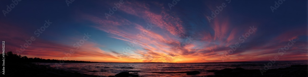 Obraz premium Breathtaking sunset over serene lake with vivid colors and dramatic clouds