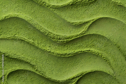 Closeup of green matcha powder texture with wavy patterns on a surface isolated on white background