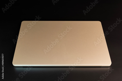 Closed laptop viewed from above on a dark background, modern technology and workspace concept