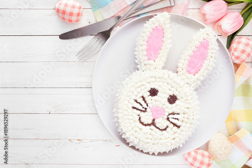 Cute Easter bunny cake. Top view table scene over a white wood background with copy space.
