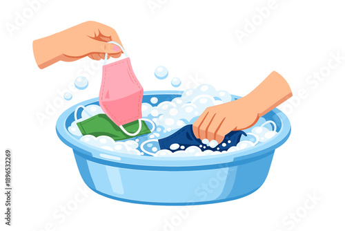 Washing face masks in a blue bowl filled with soap and bubbles during a home cleaning session at midday