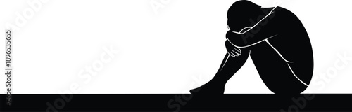 Silhouette of a person sitting and hugging their knees