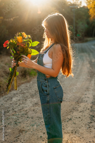 Teenage girl with flower bouquet in sunlight
