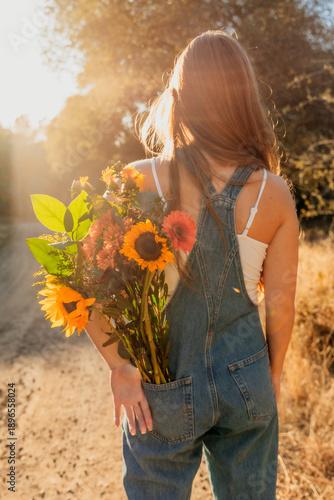Girl with flower bouquet in overalls 