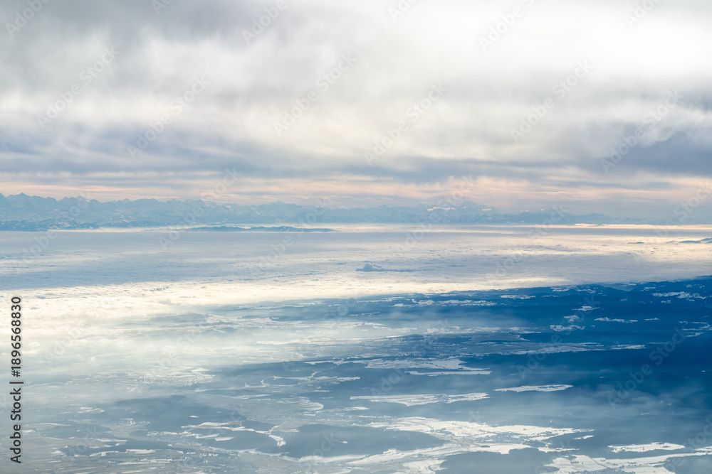 Fototapeta premium Aerial view flying towards alps and clouds during the day