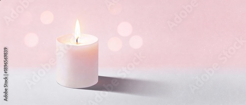 Softly glowing white candle with gentle bokeh lights on a pastel pink background