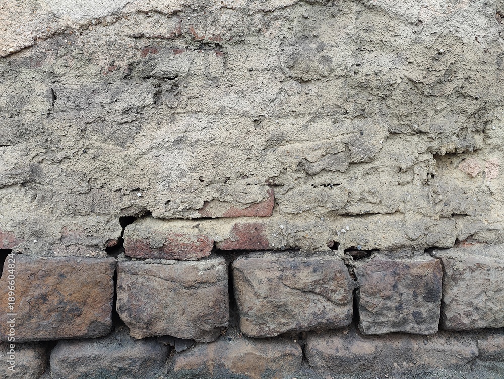 Fototapeta premium Weathered stone and brick wall with cracked mortar
