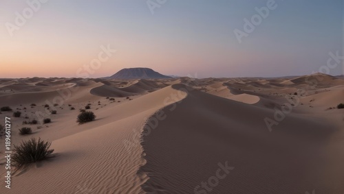 Serene Desert Dunes at Sunset with Distant Mountain.