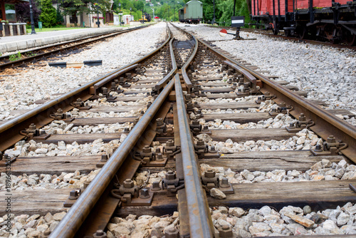 Railway switch with converging tracks at train station, illustrating transport connection, rail logistics, travel routes, and industrial infrastructure.