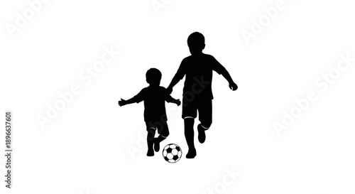 Silhouette of a father and son playing soccer together, bonding and having fun outdoors.