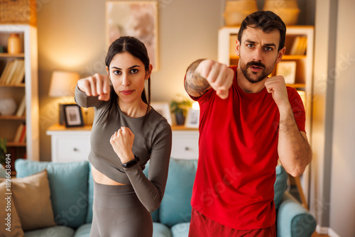 Canvastavla Couple doing front punches while working out at home