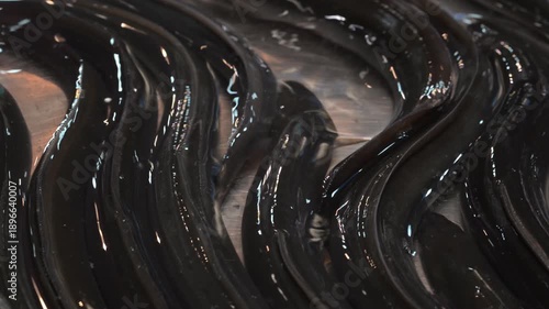 Eels laying on a metallic surface in a market during the daytime in a city location