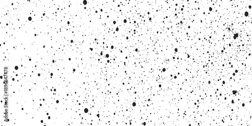 A textured pattern of liquid raindrops and splashes creates a wet surface design on a clear glass window against a dark moody sky